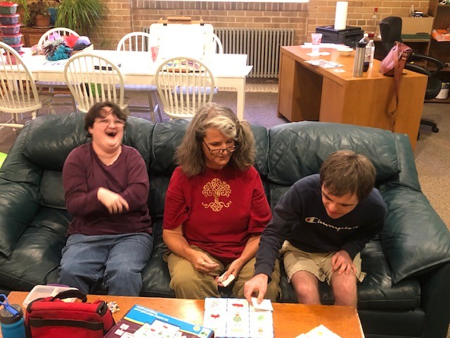Clients and staff laughing together while playing a matching game at The Shekinah Collective